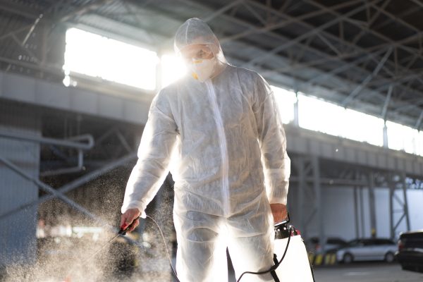Worker wearing protective suit disinfection gear disinfect surface public place parking